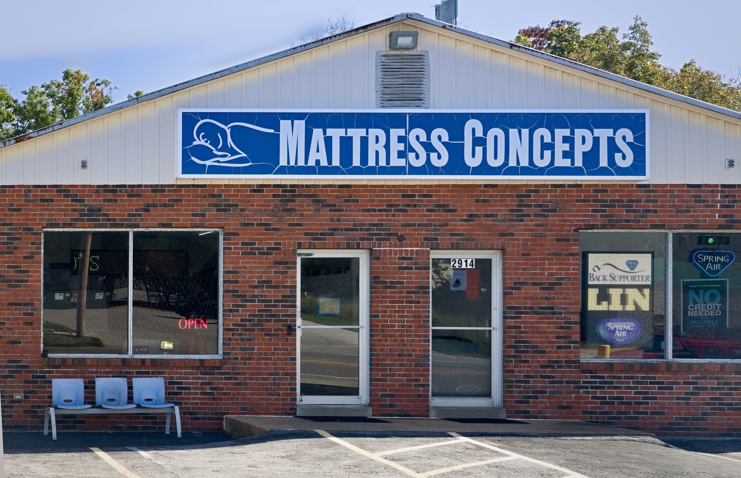 The Mattress Concepts storefront on High Ridge Blvd., with the blue sign over the doors and chairs out front